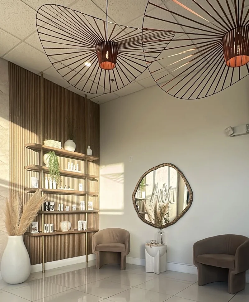 Modern and minimalist waiting area in a skincare clinic featuring neutral tones, natural wood shelving, and stylish accent lighting.